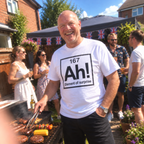 Man wearing white Ah Element of Surprise T-shirt at a garden barbecue