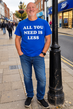 Man wearing royal blue All You Need Is Less T-shirt on UK high street