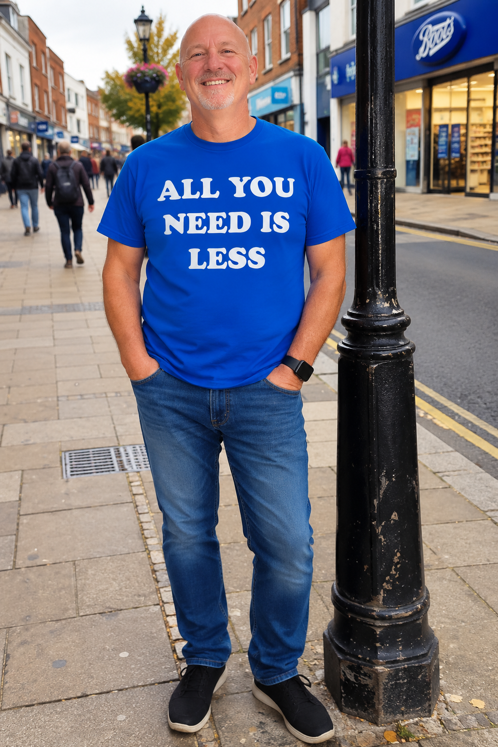 Man wearing royal blue All You Need Is Less T-shirt on UK high street