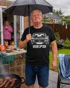Man at rainy garden barbecue wearing black BMW 1975 T-shirt