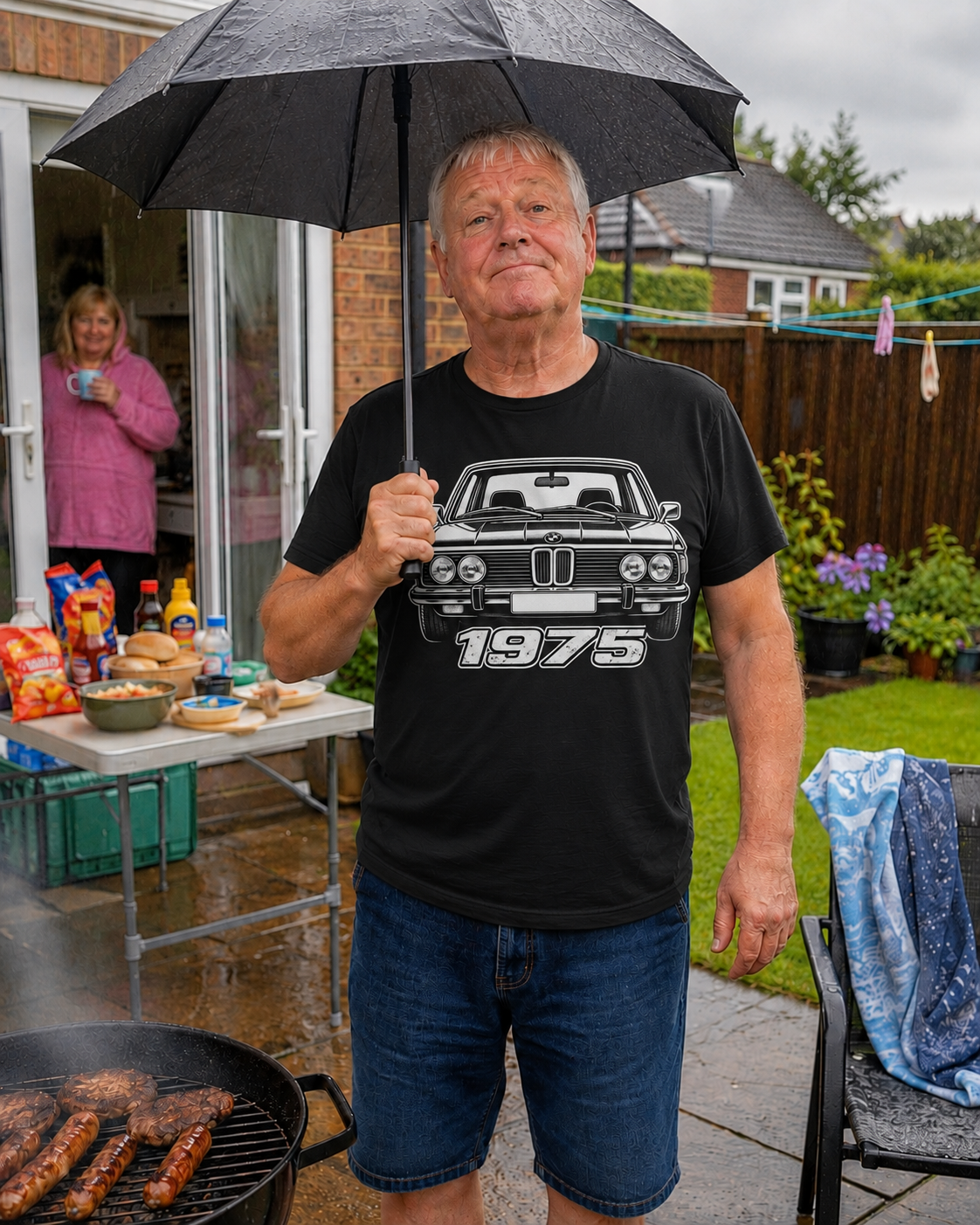 Man at rainy garden barbecue wearing black BMW 1975 T-shirt