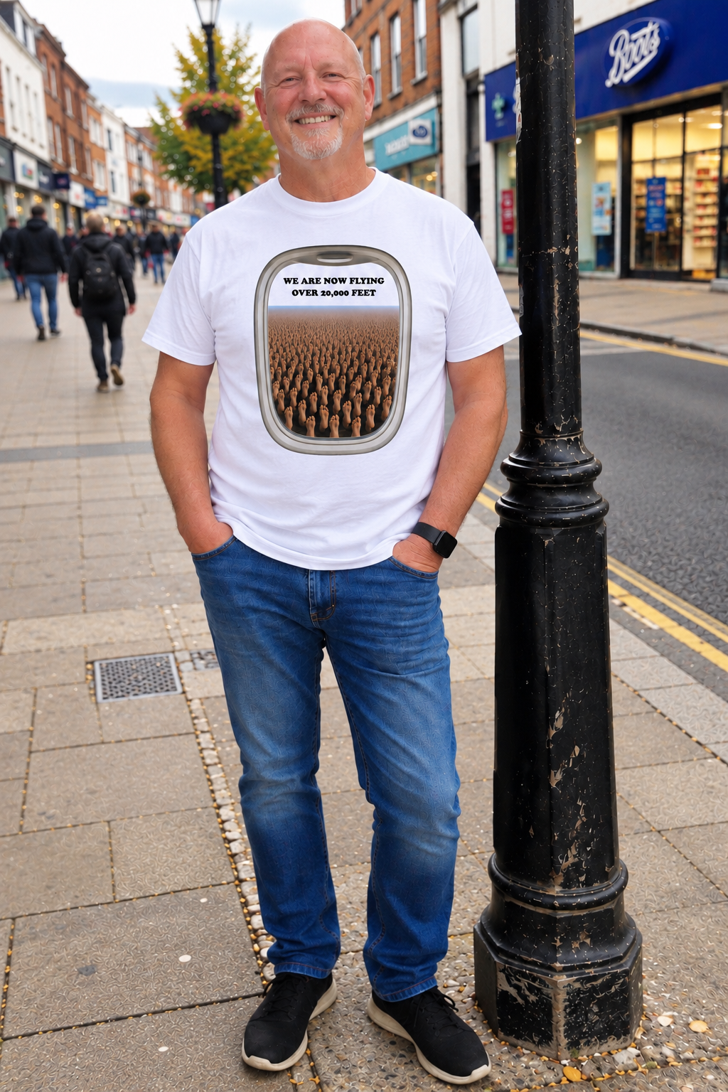 Man wearing We Are Now Flying Over 20,000 Feet white T-shirt on UK high street