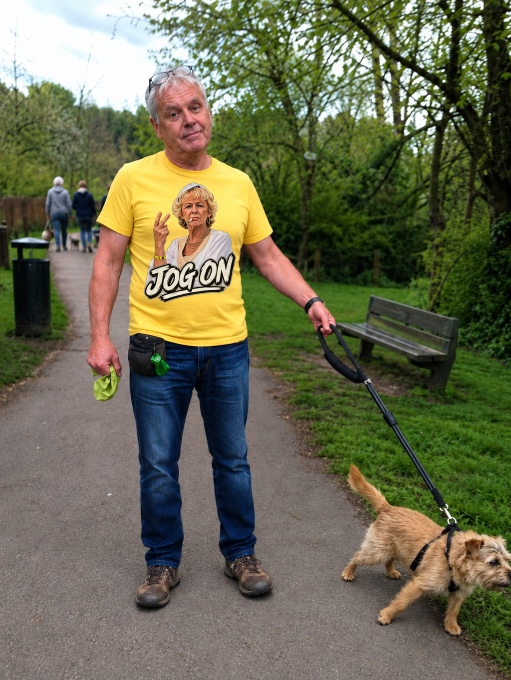 Man walking his dog in a park wearing the yellow Jog On graphic T-shirt