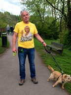 Man walking his dog in a park wearing the yellow Jog On graphic T-shirt