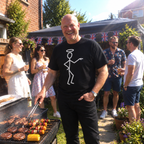 Man at a garden barbecue wearing black The Saint halo stick figure T-shirt
